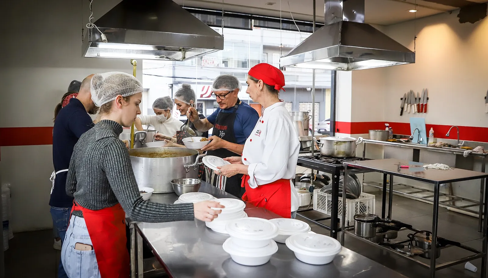 Equipe preparando refeições em cozinha industrial